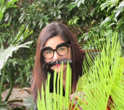 Felicia funny photo (she is hiding behind a plant wearing silly glasses)