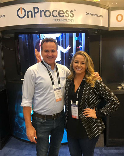 man and woman standing in front of an onprocess booth