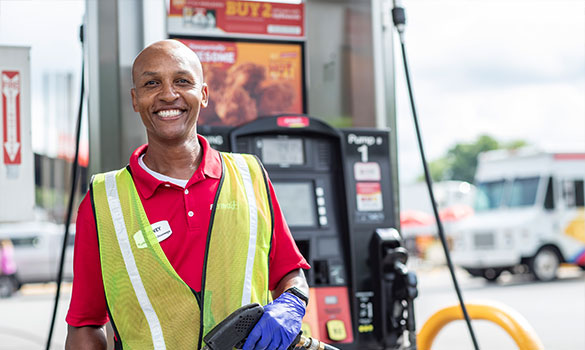 man (gas attendent) smiling at gas pump