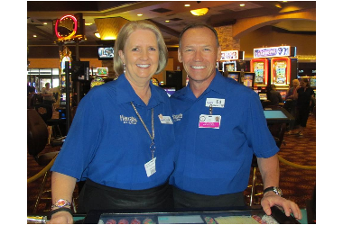 Two smiling employees in blue polos