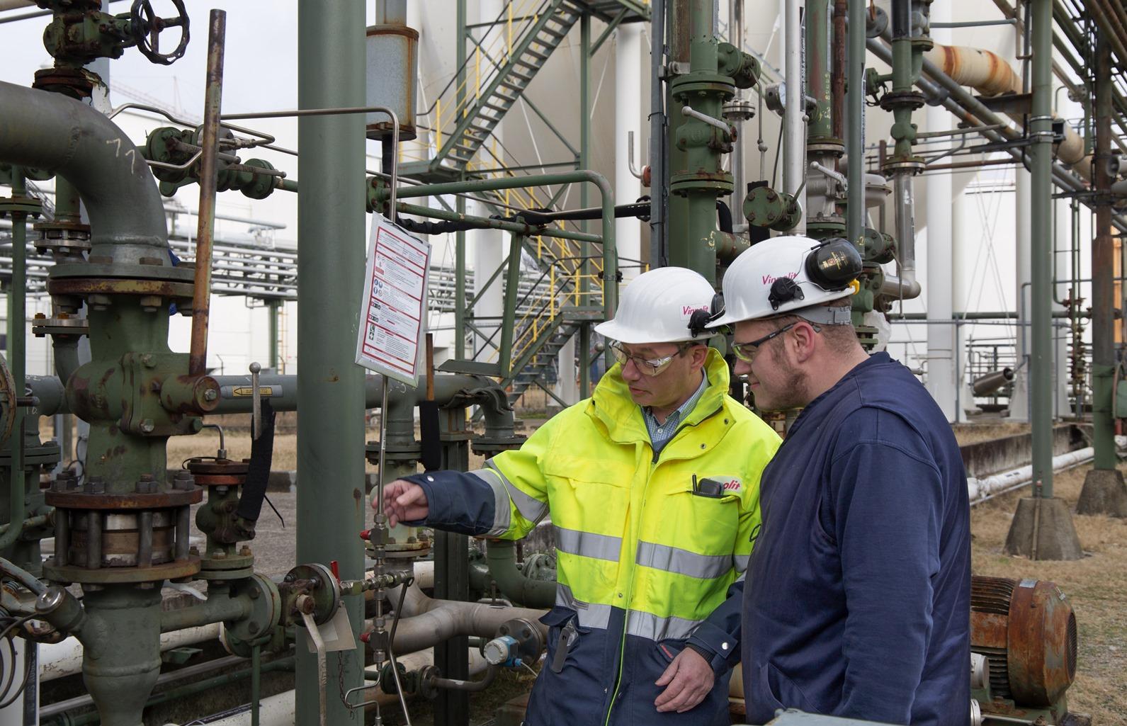 Two workers are checking the machine.