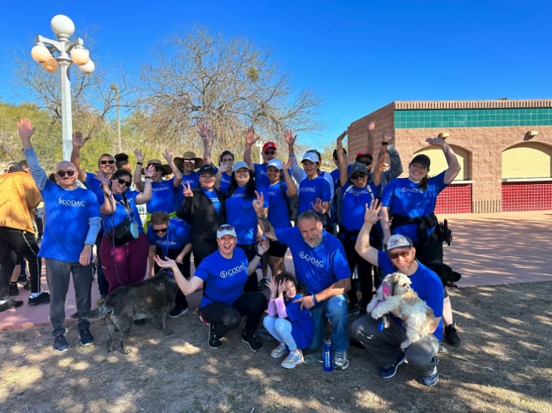 a group of people in blue shirts posing for a picture