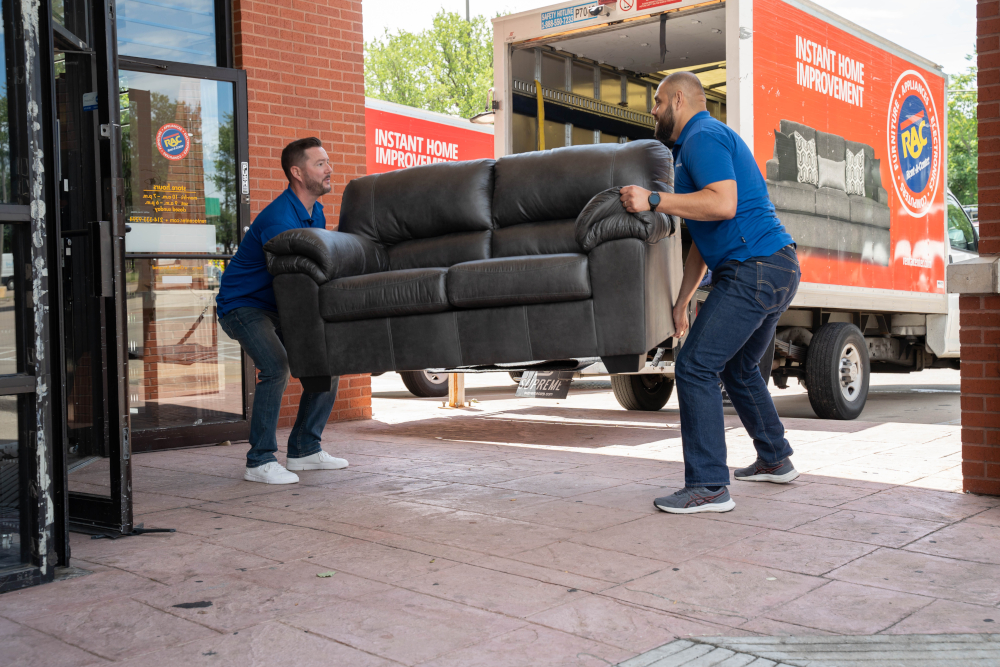 Two guys are delivering a sofa