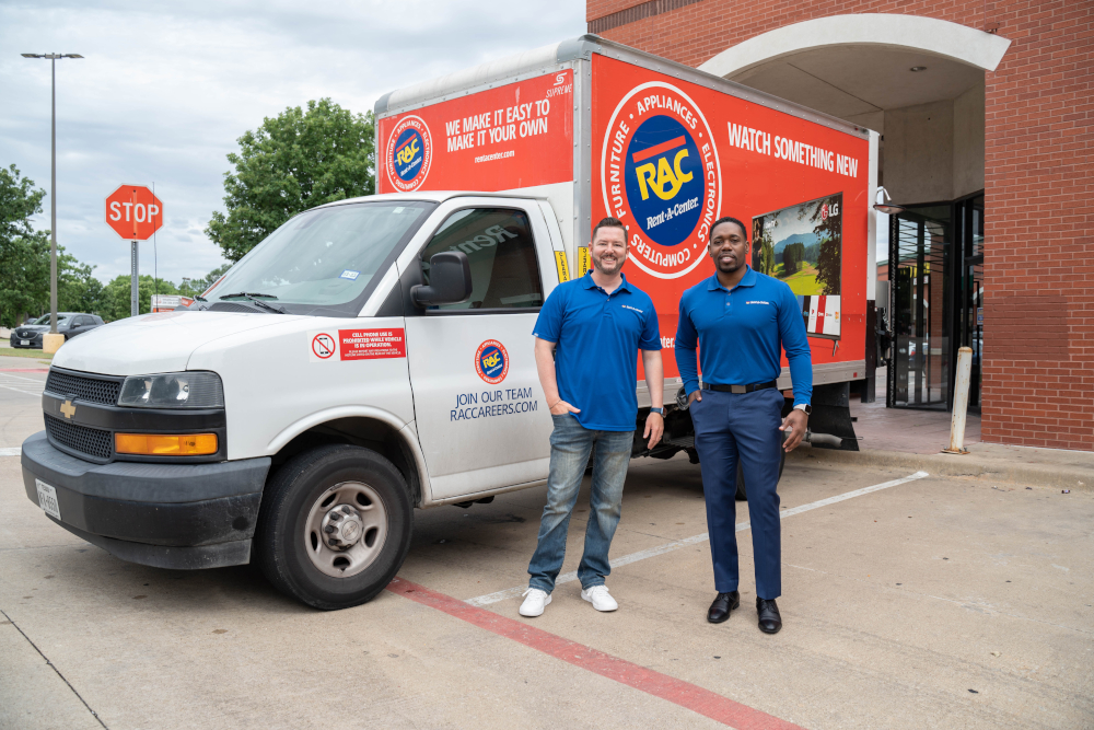 Two guys are smiling in front of a truck